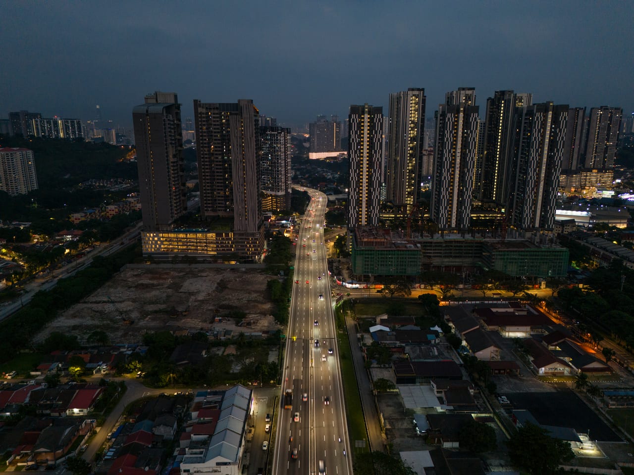 Old Klang Road night aerial — highway light trails and the Kuala Lumpur skyline